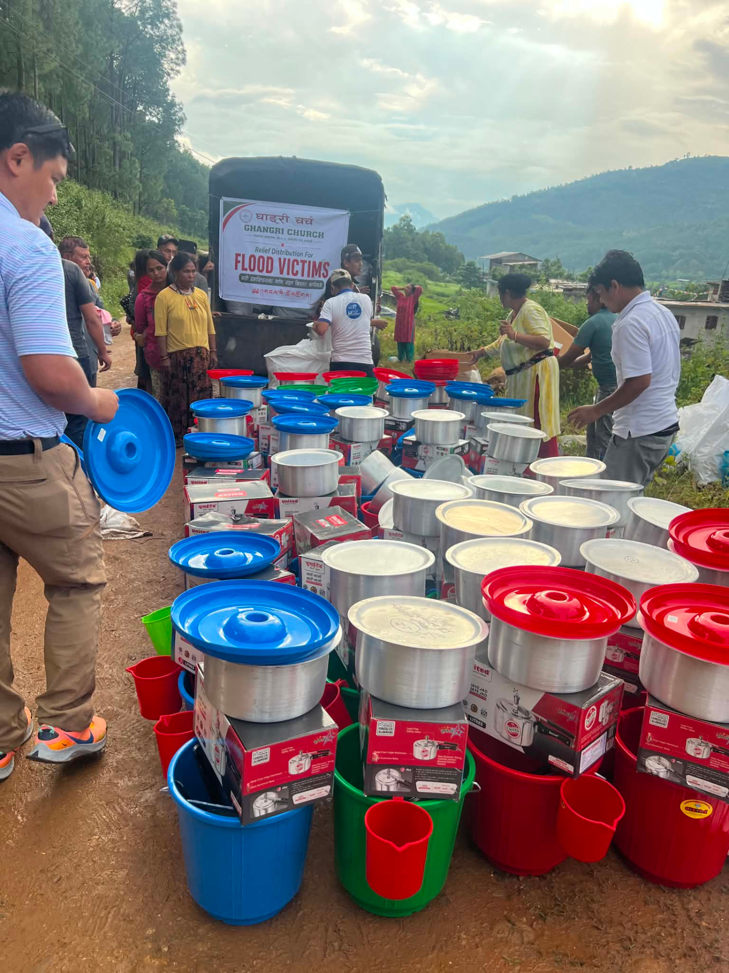 Cooking pots, pressure cookers, utensils and buckets laid out for distribution