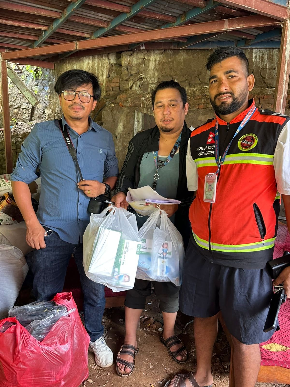 Team members handing over bags of medical supplies and masks